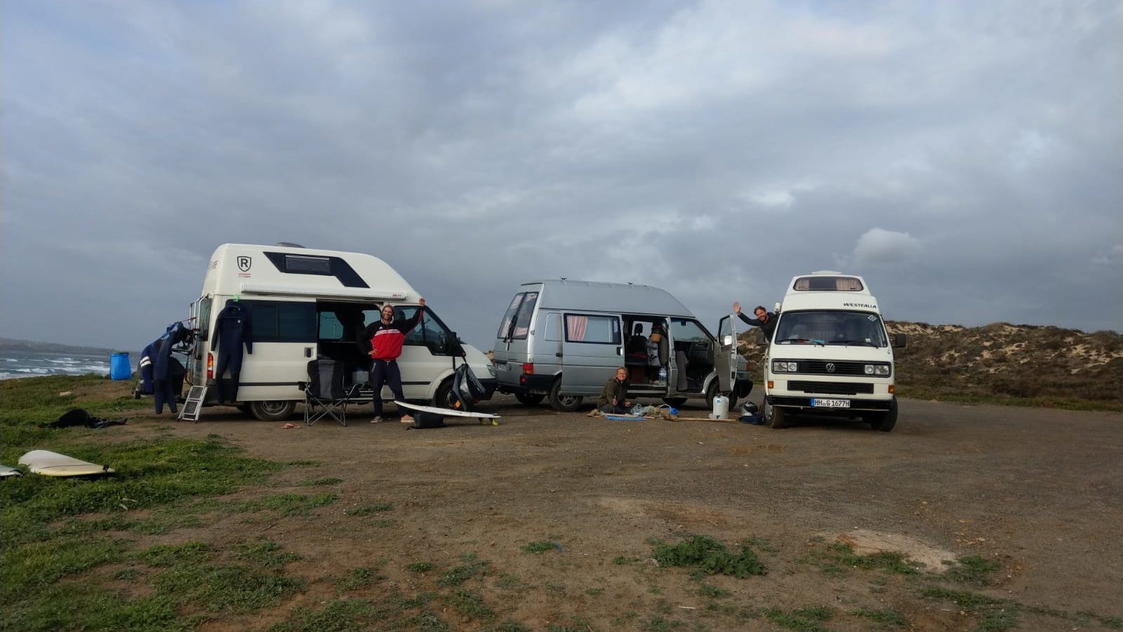 Ein Gruppe Camper steht zusammen am Strand