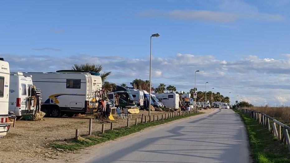 Blick auf einen Strandparkplatz mit Campern